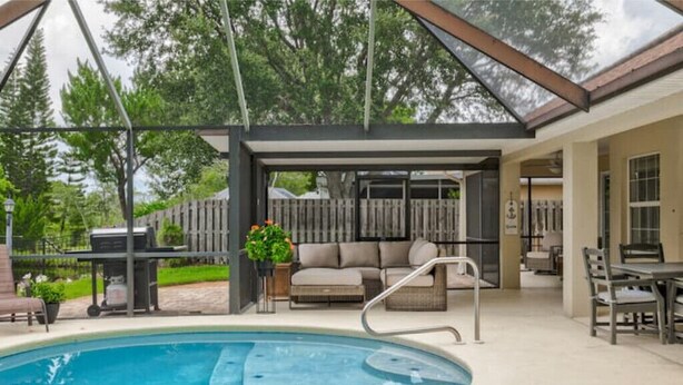 A covered outdoor swimming pool area with a hot tub, seating, and a barbecue grill. - Spacious Beachy Retreat with Heated Pool! Short walk to beach•Pet friendly•Bikes (St. Augustine)