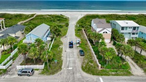 A coastal road with houses on both sides, leading to a beach. - Spacious Beachy Retreat with Heated Pool! Short walk to beach•Pet friendly•Bikes (St. Augustine)