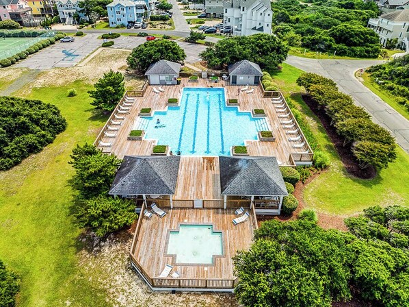 An aerial view of a resort with a central swimming pool surrounded by lounge areas and two guest houses. - Lost At Sea | 590 ft to the beach | Private Pool and Hot Tub (Corolla)