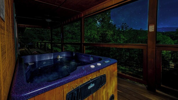 A hot tub in a wooden cabin with a night sky view. - Cozy Bear Camp - Beautiful Views, Outdoor Hot tub, Firepit + More! (Sevierville)