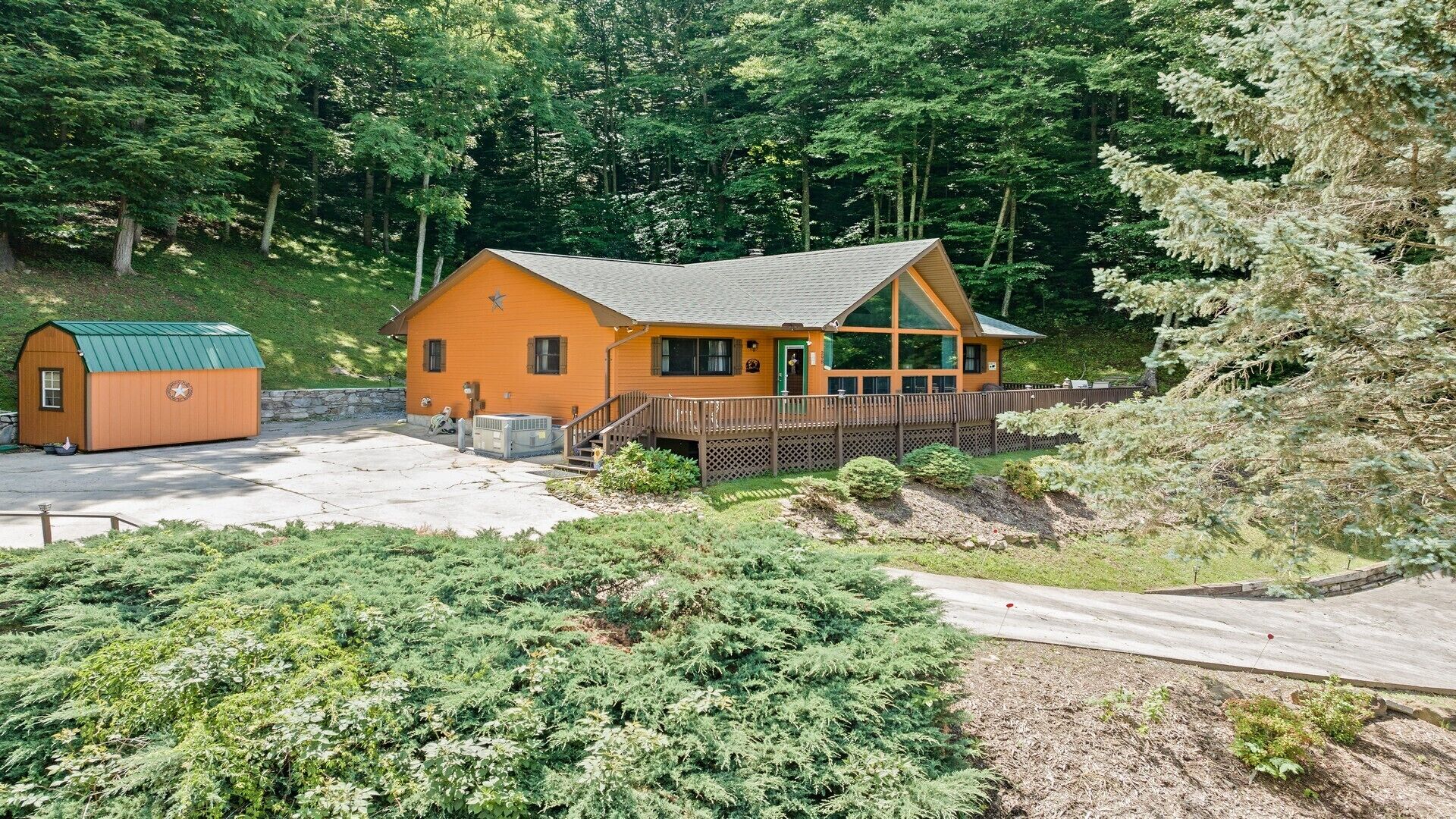 Eine Lodge mit Hauptgebäude und einem kleineren Blockhaus, umgeben von dichtem Wald.