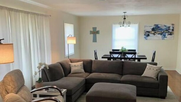 A living room with a sectional sofa, armchairs, a coffee table, and a dining area with a table and chairs. - Lida's Place - 3 BR 2 BA Ranch House - 7.6 miles to Grenada Lake (Grenada)