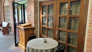 A room with a round table, a wooden cabinet, and a large wooden door with glass panels. - Lida's Place - 3 BR 2 BA Ranch House - 7.6 miles to Grenada Lake (Grenada)