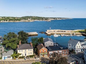 A coastal town with a marina, historic buildings, and a clear view of the sea.