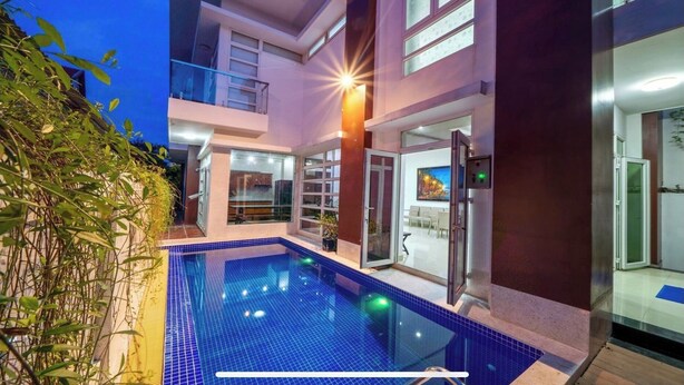 A modern two-story house with a swimming pool, glass doors, and a balcony. - Nelly Villa  | Copia Villa Hoi An (Thành phố Hội An)
