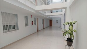 A spacious, multi-level corridor with tiled floors, white walls, and a potted plant. - VISTA SEGARIA Apartment in Vergel (Verger (el))