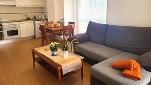 A compact living space with a kitchenette, a dining area, and a seating area with a sofa and a bench. - VISTA SEGARIA Apartment in Vergel (Verger (el))