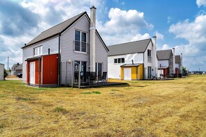 Zona residencial con casas que tienen garajes incorporados y un patio con césped.