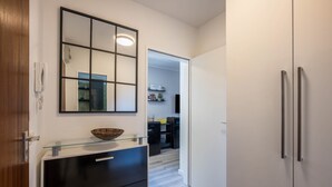 A modern kitchen with a glass-top island, a large mirror, and a refrigerator. - Holiday Apartment 'Time 2 Sea' with Shared Garden, Balcony and Wi-Fi (Scharbeutz)