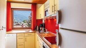 Cocina compacta con vista por la ventana, microondas, estufa y refrigerador.