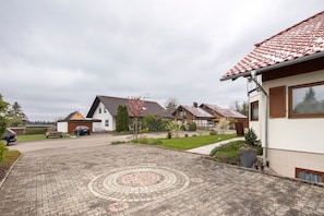 Une rue résidentielle bordée de maisons, avec une allée pavée et un jardin.