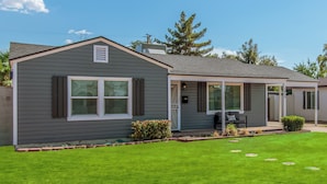 A single-story house with a covered porch, a small front yard, and a well-maintained lawn. - Charming Bungalow in the heart of Phoenix/Biltmore area.  (Phoenix)