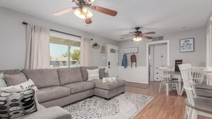 A modern living room with a sectional sofa, a dining table with chairs, and ceiling fans. - Charming Bungalow in the heart of Phoenix/Biltmore area.  (Phoenix)