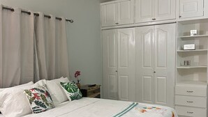 A bedroom with a bed, a wardrobe, and a nightstand.