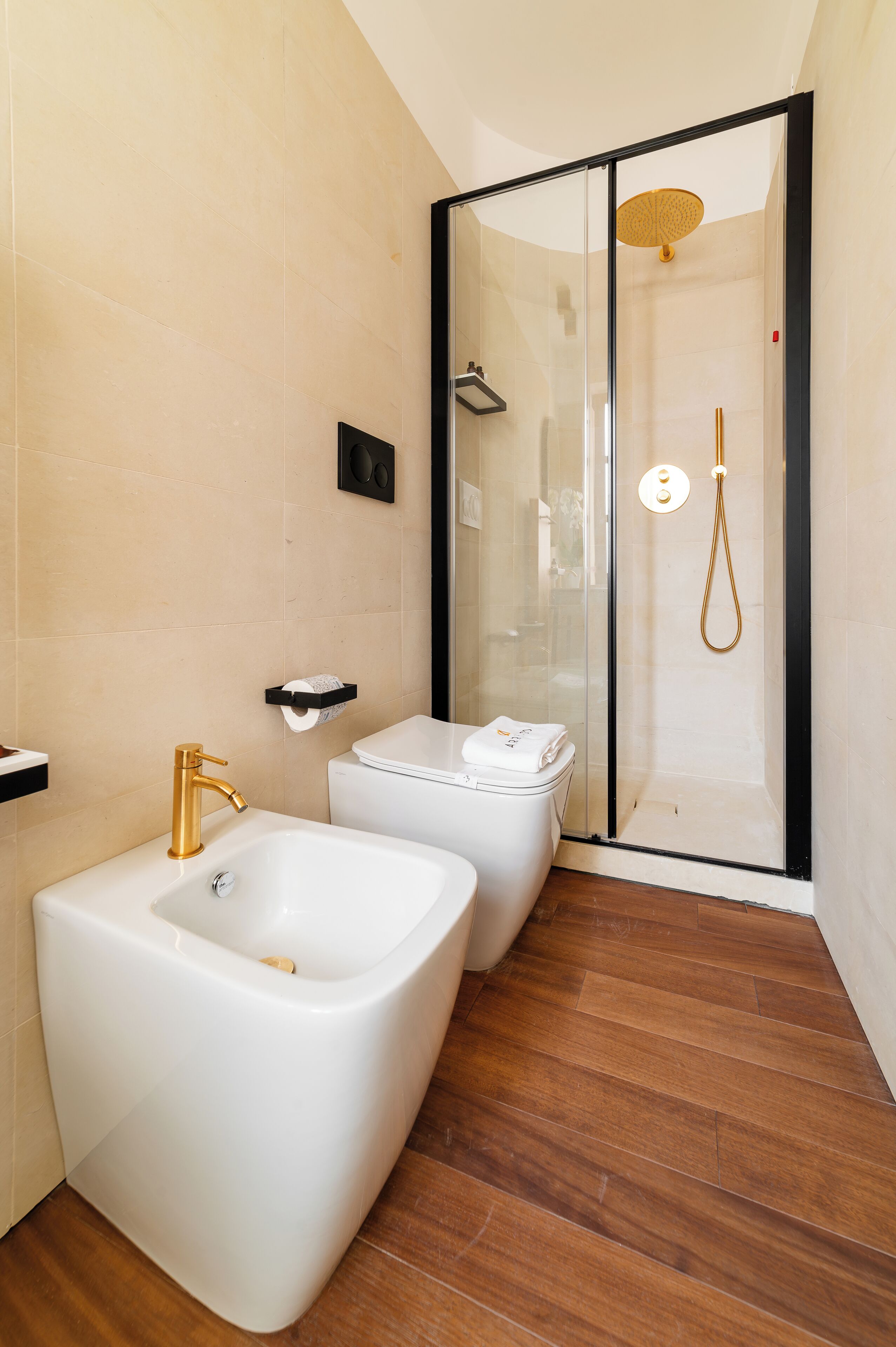 Une salle de bain moderne avec une douche à parois de verre, un lavabo blanc et des toilettes.