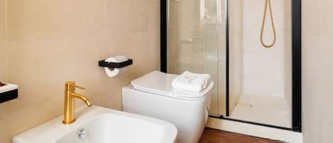 Une salle de bain moderne avec une douche à parois de verre, un lavabo blanc et des toilettes.