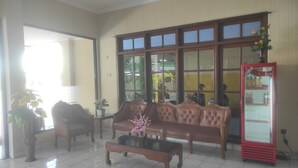 A living room with a sofa, coffee table, and a refrigerator.