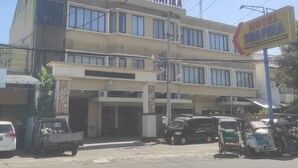 A hotel named Hotel Shafira with a modern facade, multiple windows, and a signboard.