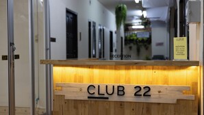 A reception desk labeled "CLUB 22" with a sign indicating "Reception" and a contact number. - Club 22 Kamala Suites (Kamala)