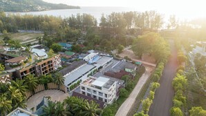 An aerial view of a coastal town with buildings, roads, and a beach. - Club 22 Kamala Suites (Kamala)