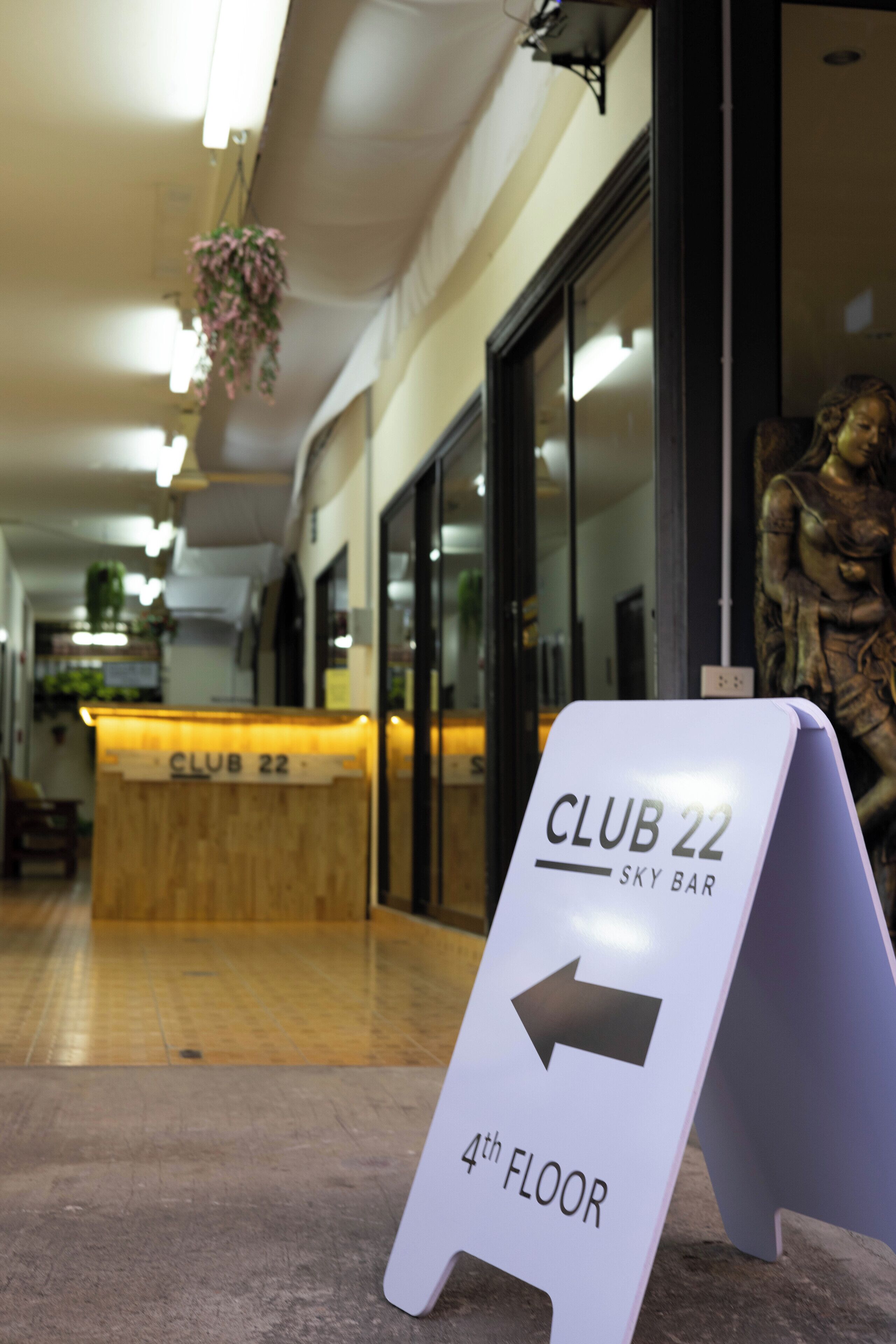 A sign indicating the direction to Club 22 Sky Bar on the 4th floor.