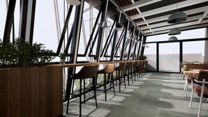 A modern bar area with a long counter, multiple bar stools, and pendant lighting. - Funhome Bo Song Set Apartment Ha Noi (Hanoi)
