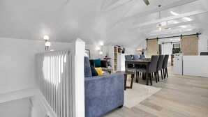 Un espacio habitable moderno con sofá, mesa de comedor y sillas.