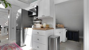 A modern kitchen with white cabinetry, stainless steel appliances, and a built-in oven. - Capitola Village Work-Live Loft - Pet Friendly (Capitola)