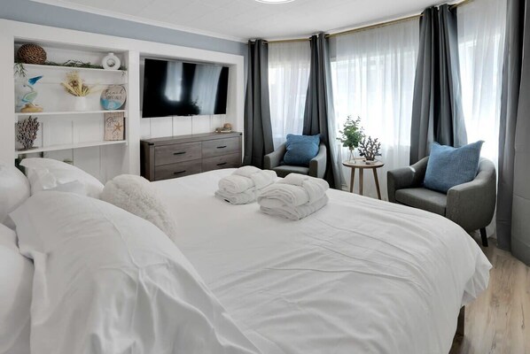 Ein Hotelzimmer mit einem großen Bett, einem Fernseher, einem Schreibtisch und zwei Stühlen.
