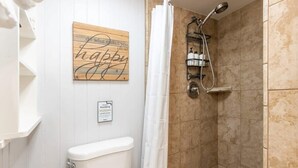 A bathroom with a shower, toilet, and a sign on the wall. - Capitola Village Hideaway Bungalow - Pet friendly! (Capitola)