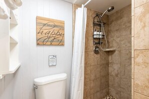 Ein Badezimmer mit Dusche, Toilette und einem Schild an der Wand.