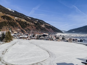 A snow-covered ski resort with buildings and a ski slope. - Apartment with balcony not far from the skilift (Neukirchen am Großvenediger)