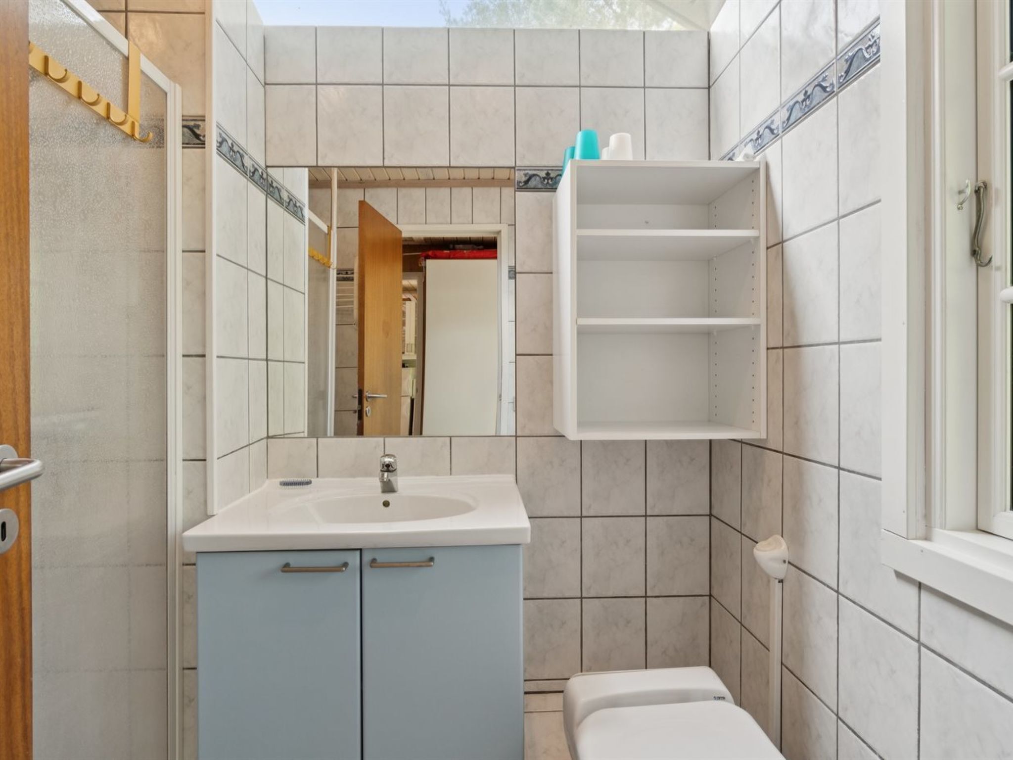 Un bagno con lavandino, specchio e WC.