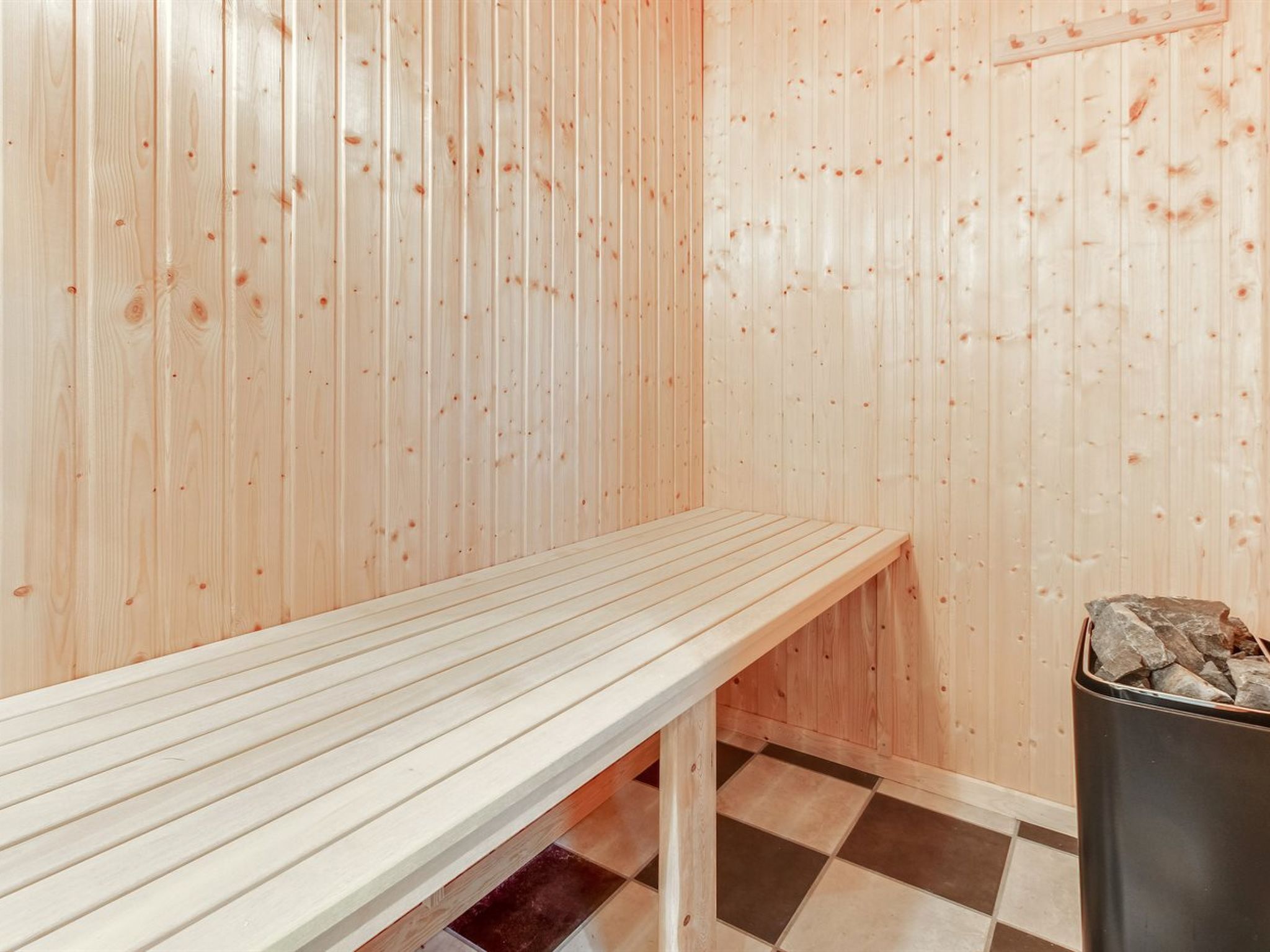 Un sauna avec des murs en bois et un banc.
