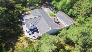 A two-story building with a sloped roof, surrounded by dense forest. - "Minka" - 300m from the sea by Interhome (Nexø)