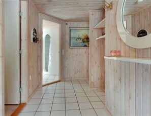 Stunning hallway with a painting and mirror, featuring a tiled floor and a door.