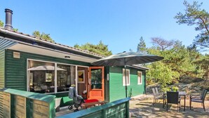 A green cabin with a porch, a table and chairs, and a stroller. - "Michel" - 300m from the sea by Interhome (Nexø)