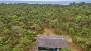 A small, single-story building surrounded by dense forest, with a clear view of the ocean in the background. - "Michel" - 300m from the sea by Interhome (Nexø)