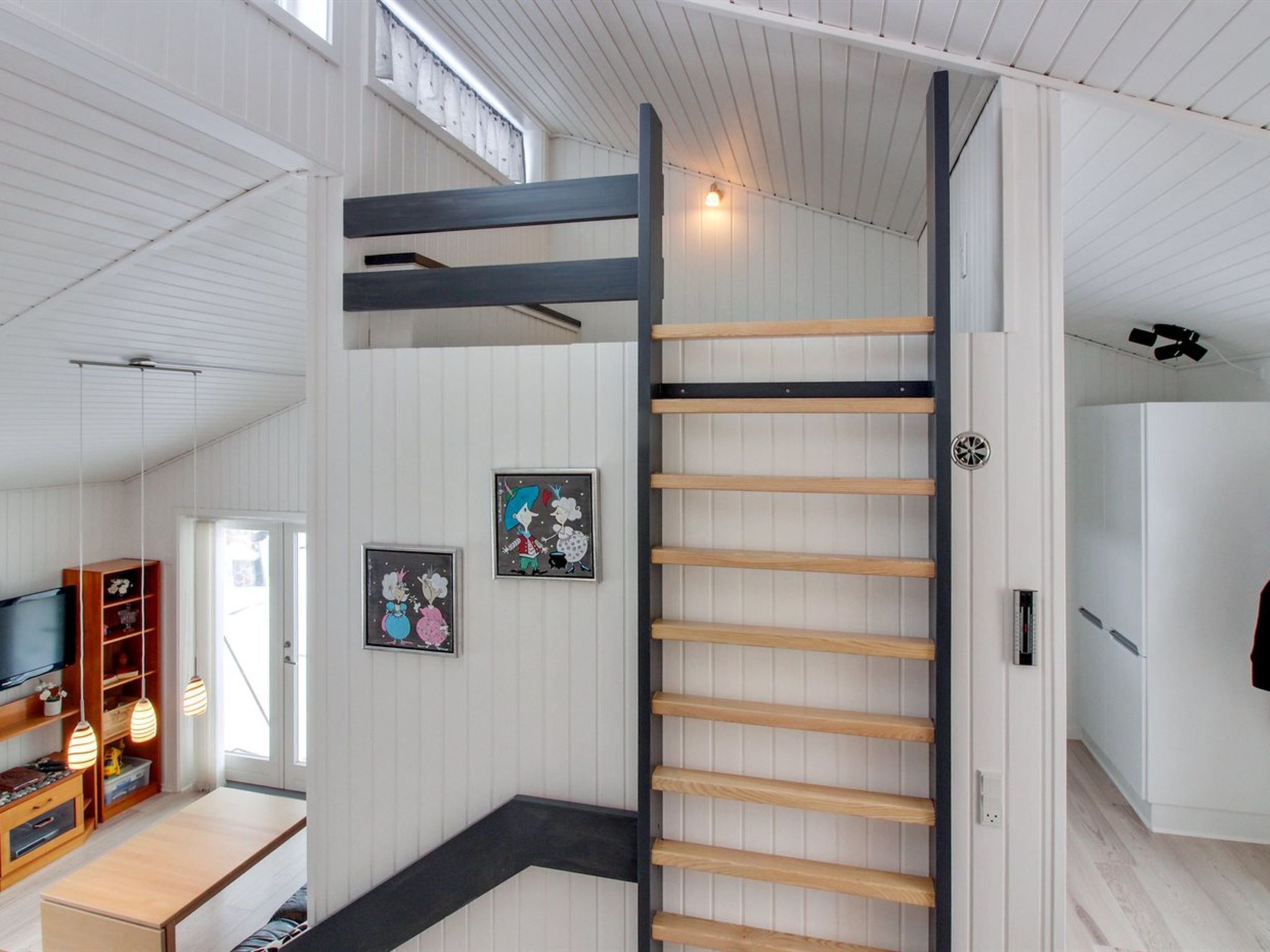 A modern interior with a loft bedroom, a dining area, and a kitchen.