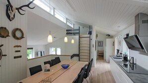 A modern kitchen with a wooden table and chairs, a large window, and a view of the outdoors. - "Antigona" - 250m from the sea by Interhome (Nexø)