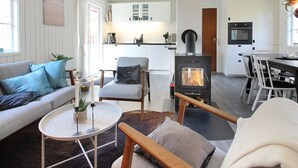 A modern living room with a sofa, armchairs, a round coffee table, and a fireplace. - "Ronja" - 300m from the sea by Interhome (Nexø)