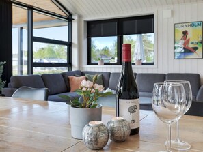 A modern living room with a sofa, a table with a wine bottle and glasses, and decorative jars. - "Ignat" - 175m from the sea by Interhome (Nexø)