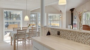 A modern kitchen with wooden cabinets, a tiled backsplash, and pendant lighting. - "Arndis" - 600m from the sea by Interhome (Nexø)