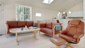 A modern living room with a wooden ceiling, a large window, a sofa, a chair, and a table. - "Arndis" - 600m from the sea by Interhome (Nexø)