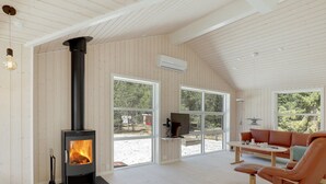 A modern living room with a wood-burning stove, a sofa, and a TV. - "Arndis" - 600m from the sea by Interhome (Nexø)