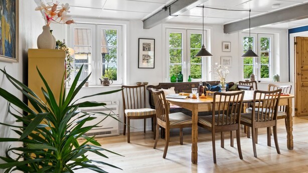 A dining area with a wooden table and chairs, large windows, and a ceiling with exposed beams. - "Hansen" - 5.2km from the sea by Interhome (Aakirkeby)