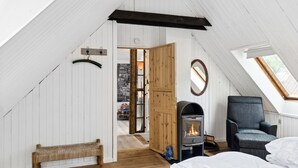 A cozy attic bedroom with a wooden bench, a sofa, a fireplace, and a skylight. - "Hansen" - 5.2km from the sea by Interhome (Aakirkeby)