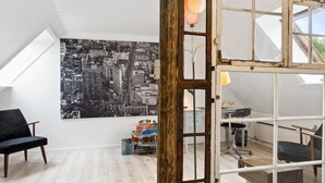 A loft-style room with a cityscape mural, a wooden door, and a skylight. - "Hansen" - 5.2km from the sea by Interhome (Aakirkeby)