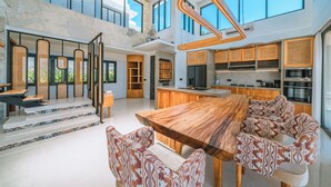 A spacious kitchen with a large island, modern appliances, and a high ceiling with skylights. - Villa Asri -  Tropical 3BR Villa (Tabanan)