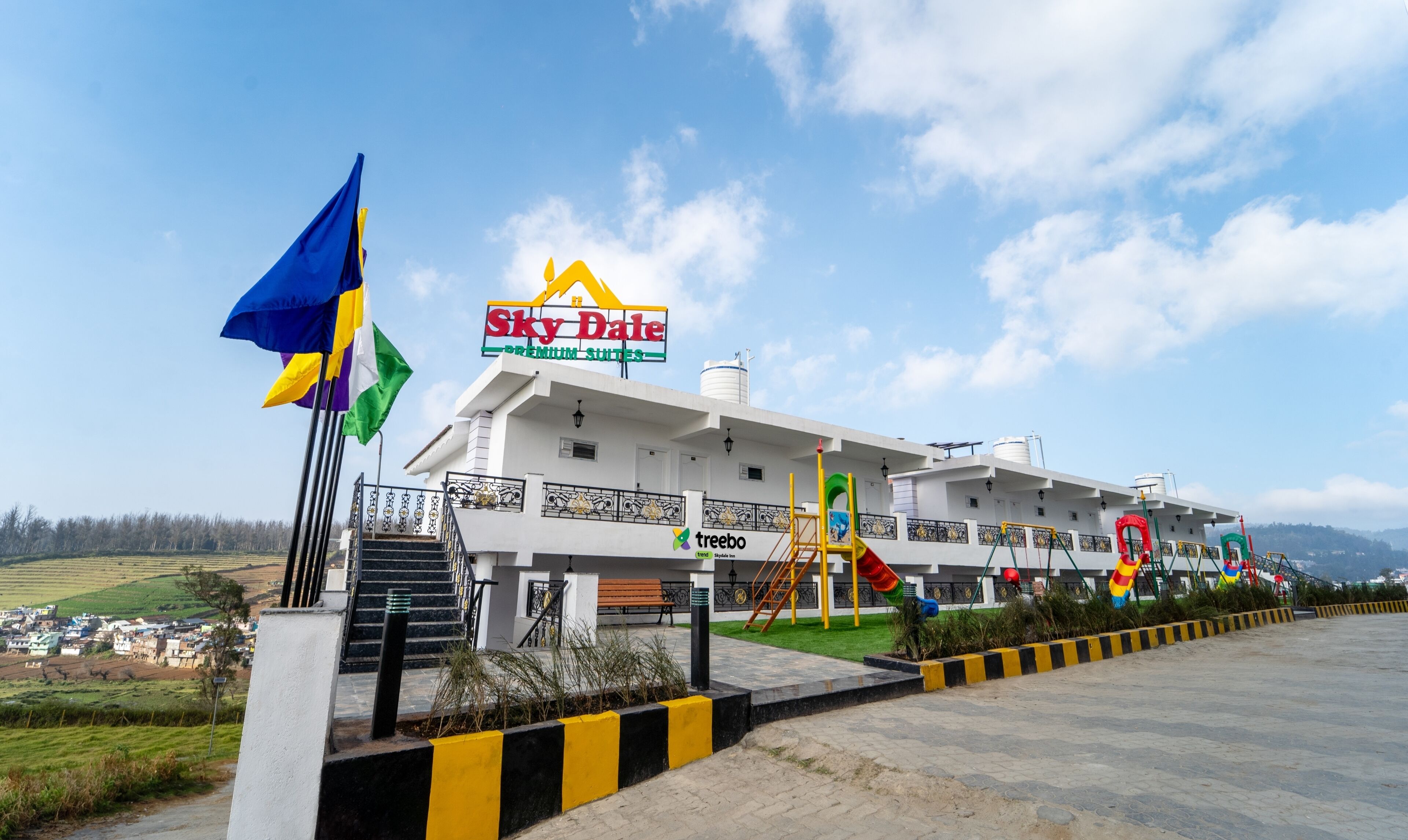 A hotel with a sign for 'Sky Dale Premium Suites' and a playground area.